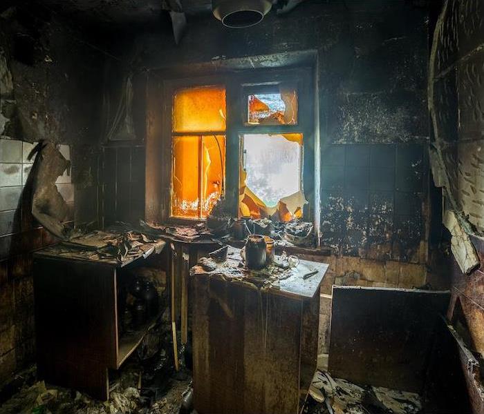 Fire Damaged Kitchen with melted and soot-covered appliances and walls